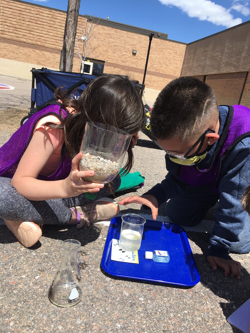 Two students outside doing an experiment