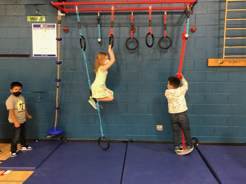 Three students on ropes in gym